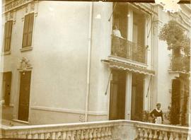 Woman on a balcony with servant below