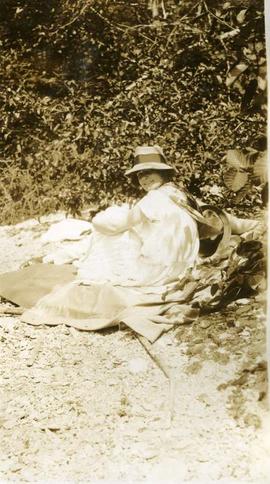 woman sitting on a blanket in wooded area