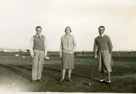 Two men and a woman golfing