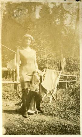 woman in stockings and bathing costume standing near a fence