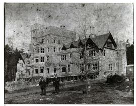 Hatley Castle from south east under construction. Two men in foreground.