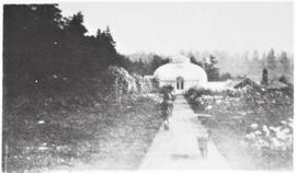 Child and dog running on path to conservatory