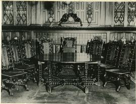 dining room table with 8 chairs arranged in front of dining room fireplace.