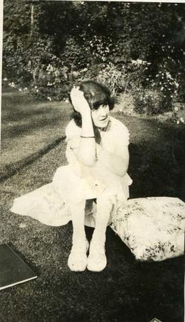 woman seated on a cushion on lawn