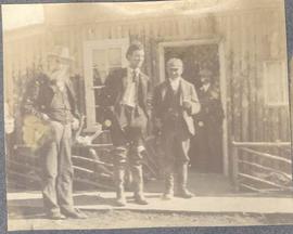 three men by a building, another in the doorway