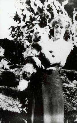 Woman in a black skirt holding a dog