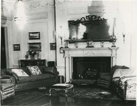 drawing room with chairs and a footstool arranged at east fireplace.