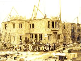 Hatley Castle from north east under construction. Stonemasons in foreground and one man on roof