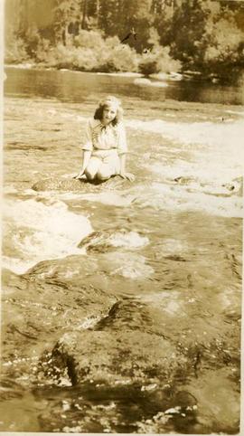 girl on a rock in a river