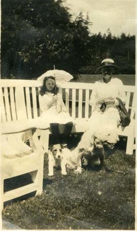 Girl and woman with two dogs on benches between Italian and Japanese gardens, Hatley Park