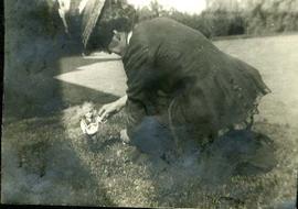 Woman playing with doll on grass