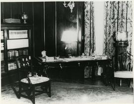 castle library, showing south east corner with bookshelves and a writing desk.